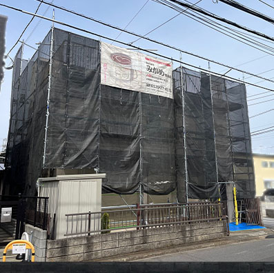 塗装工事の足場にシートをつけたお家